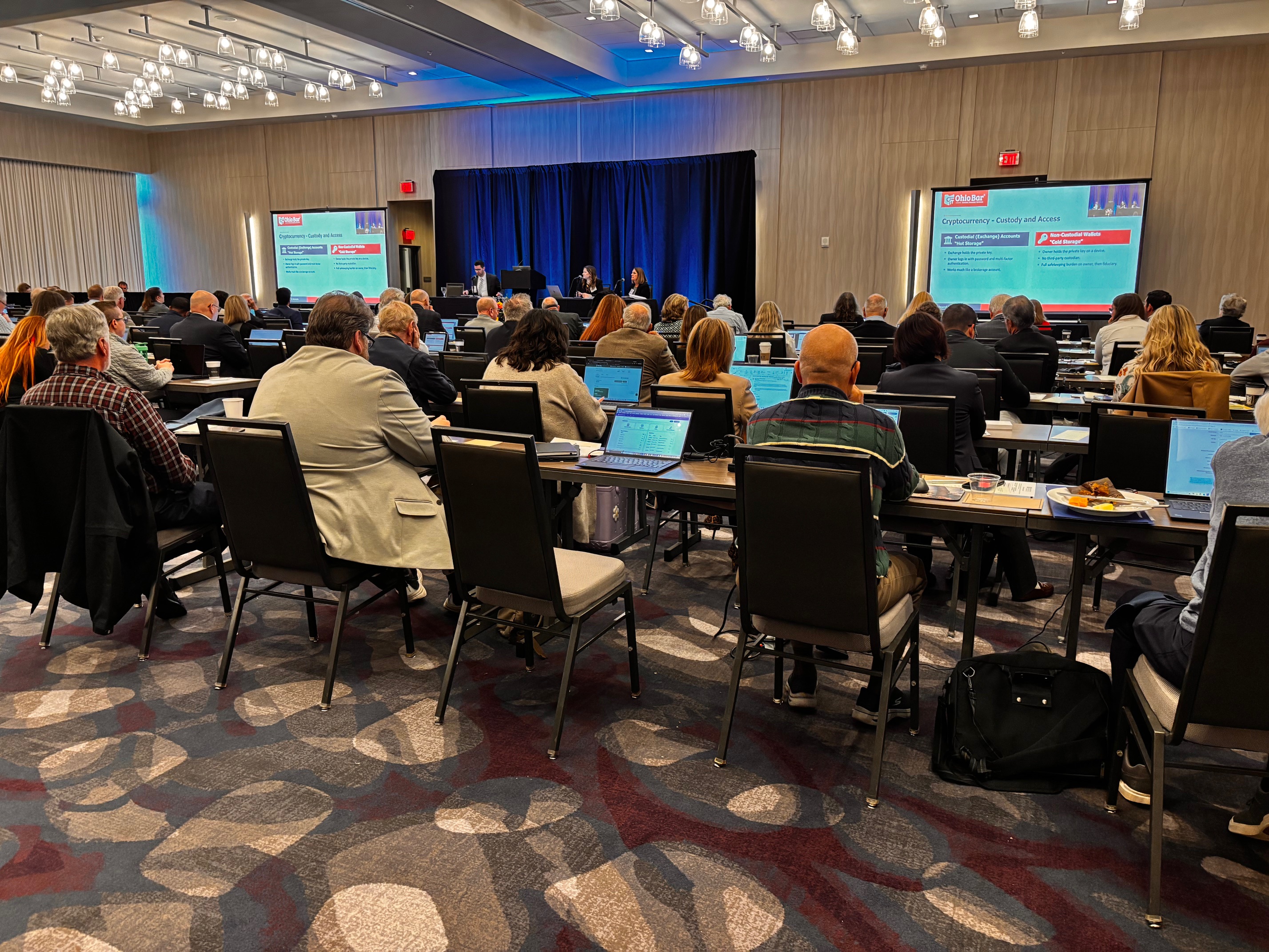 Attendees at the 2026 Pliskin Institute watching a panel on cryptocurrency custody and access